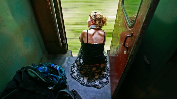 A tourist looks out the train on the way to Galle. 