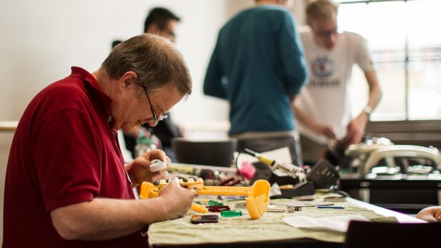 We'll have a go: Volunteer Daryl Maunder mends a broken toy at the free Melbourne Repair Cafe in Yarraville.