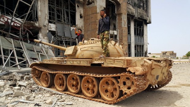 Libyan pro-government forces stand on a tank in Benghazi, Libya. The country is close to anarchy and is now IS' third biggest stronghold.