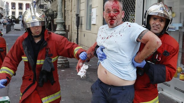 A man is taken away by emergency service workers after he was injured in clashes in downtown Marseille, France.