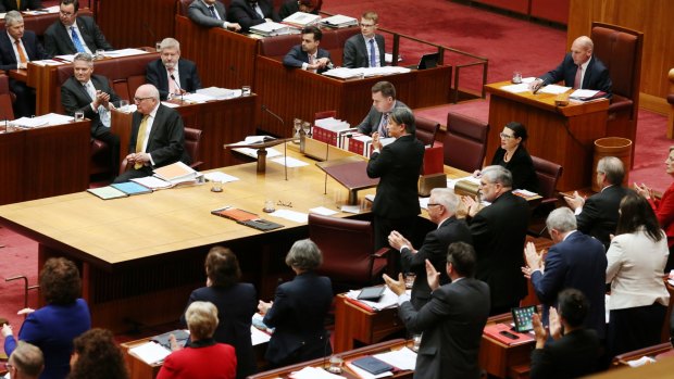 Labor senators give Attorney-General George Brandis an unprecedented standing ovation while his Coalition colleagues remain seated following his criticism of Pauline Hanson.
