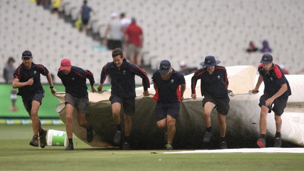 Run for cover: Rain on day four squandered hope of an English victory in Melbourne.