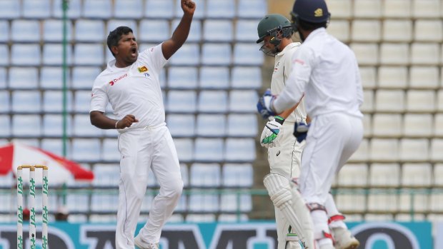 Gone cheaply: Sri Lanka's Rangana Herath celebrates the wicket of David Warner.