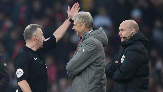 Referee Jonathan Moss orders Arsene Wenger to leave from the touchline.