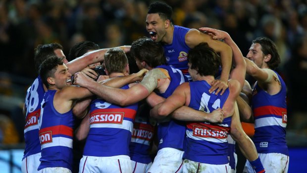 The Western Bulldogs celebrate after dethroning Hawthorn.