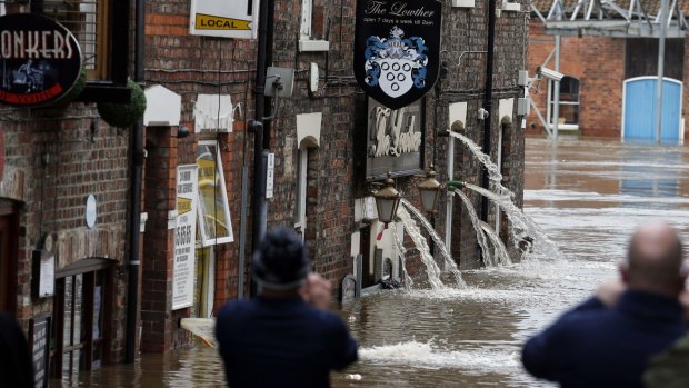 Flood water is pumped out of pubs after flooding in York, Britain, on Monday.