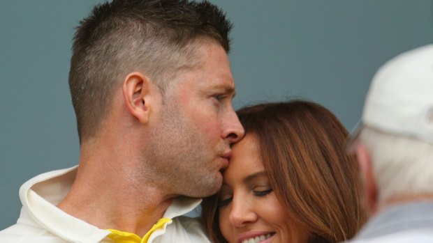 Michael Clarke kisses wife Kyly as he waits during a rain delay during day two of the First Test match between Australia and India.