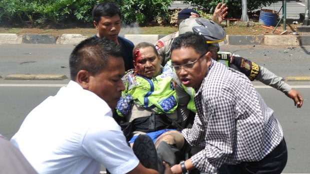 People carry an injured police officer near the site where an explosion went off at a police post in Jakarta last week.