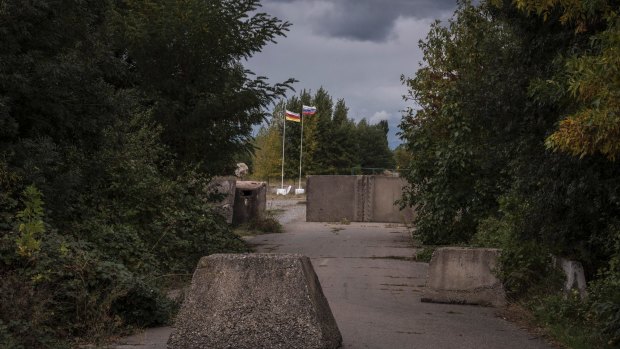 Concrete bollards mark the "border" between Georgia and the breakaway region of South Ossetia outside Gori, Georgia. The Russian and Ossetian flags can be seen in the distance.