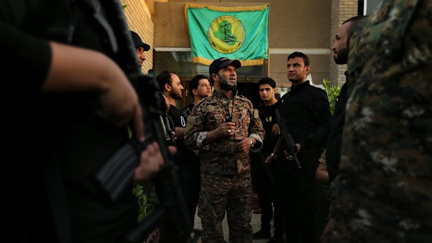 Haji Jaffer al-Bindawi, a leader of the Imam Ali Brigades, an Iraqi Shiite militia fighting Islamic State, with  his men  in Baghdad  in October 2014. 