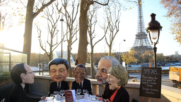 Protesters dressed as world leaders under the Eiffel Tower.