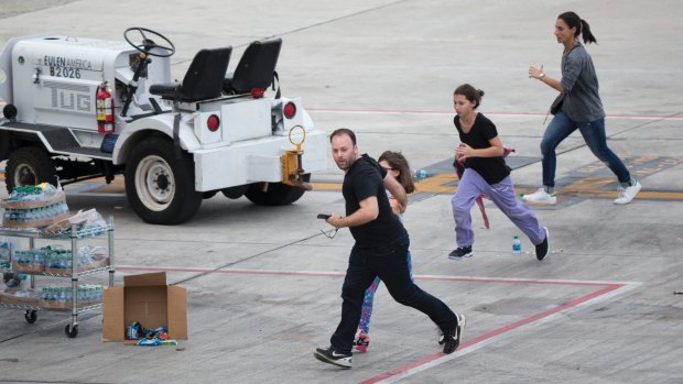 People run on the tarmac at Fort Lauderdale Airport, after a gunman opened fire. 