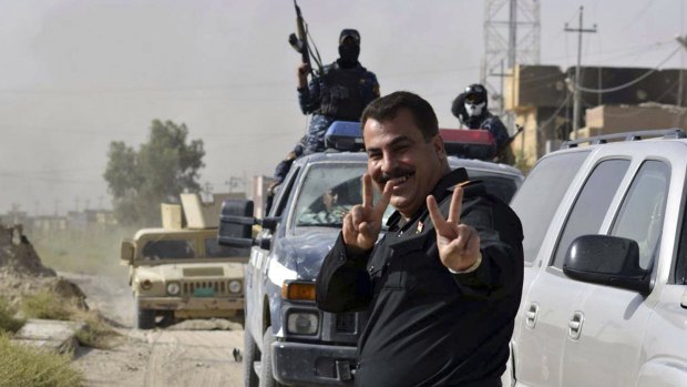 Iraqi security forces celebrate in central Fallujah, Iraq, after fighting against the Islamic State militants.