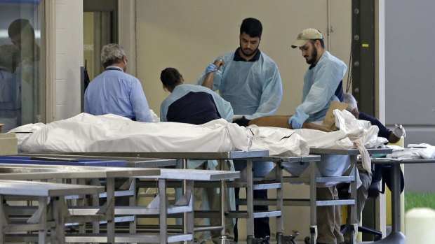 Medical personnel examine a body at the Orlando Medical Examiner's Office.