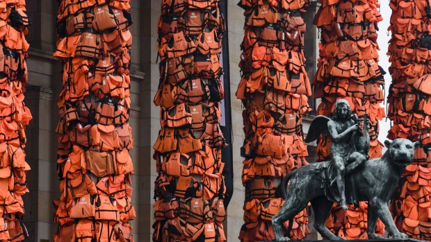 An art installation by Chinese artist Ai Weiwei features refugees' life vests wrapped around the pillars of Berlin's Konzerthaus. 