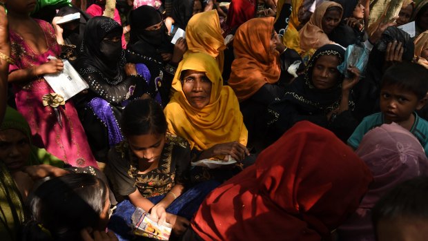 Rohingya omen and children queue at a Red Cross distribution point in Burma Para refugee camp in Bangladesh.
