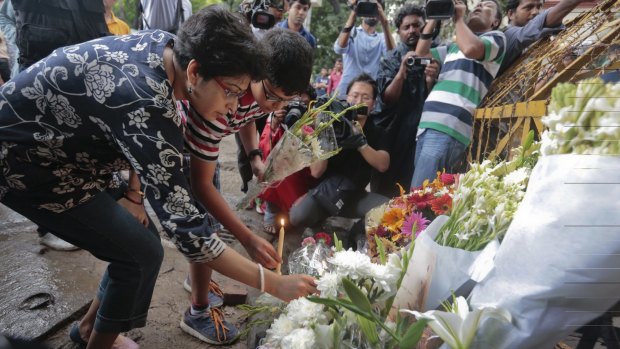 Members of an Indian family offer flowers and light candles as they pay tribute to those killed in Dhaka.