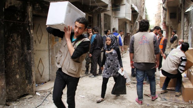 Charity staff distribute aid to the residents of the besieged Yarmouk camp in March of this year. Islamic State overran the camp on April 1.