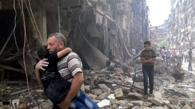 A man carries a child after airstrikes hit Aleppo on Thursday.