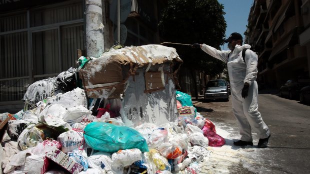 Piraeus city hall has hired a private companies to spray hills of rubbish with a calx as mounds of rubbish festered in soaring temperatures in Athens.