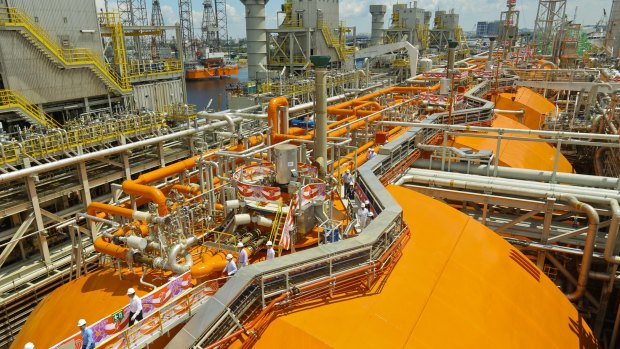 Crew members walk on board a floating liquefaction vessel built by Keppel Offshore and Marine.