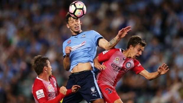 Sydney FC's Filip Holosko muscles out Josh Rose (right) for a header. 