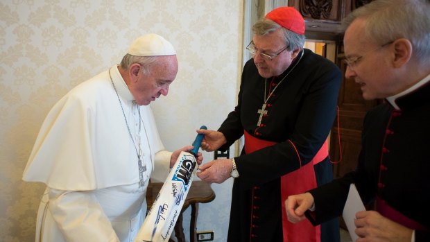 Pope Francis receives a cricket bat from Cardinal George Pell at the Vatican in 2015.