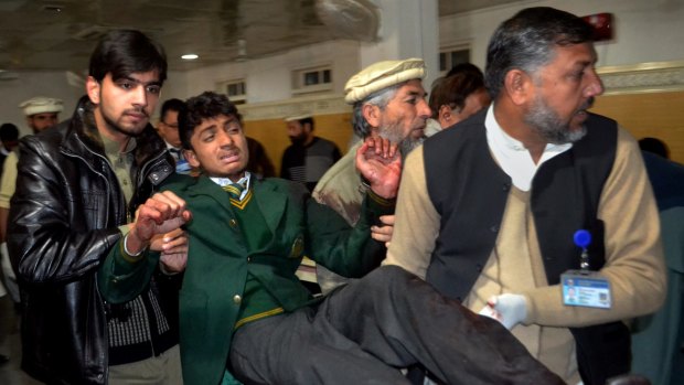 Pakistani volunteers carry a student injured after an attack by Taliban gunmen to a local hospital in Peshawar.