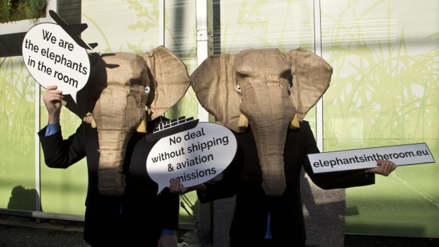 Representatives of NGOs wear elephant masks and hold banners at the United Nations Climate Change Conference in Paris.