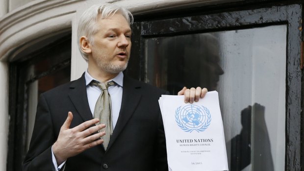 Julian Assange, pictured on the balcony of Ecuador's London embassy, holds the UN report that says he is being 'arbitrarily detained' by Britain and Sweden.