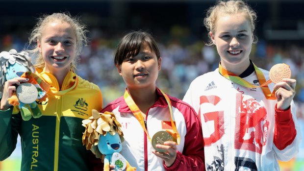 Silver medallist Holt, gold medallist Zhou Xia of China and Maria Lyle of Great Britain pose on the podium at the medal ceremony for the women's 100m.