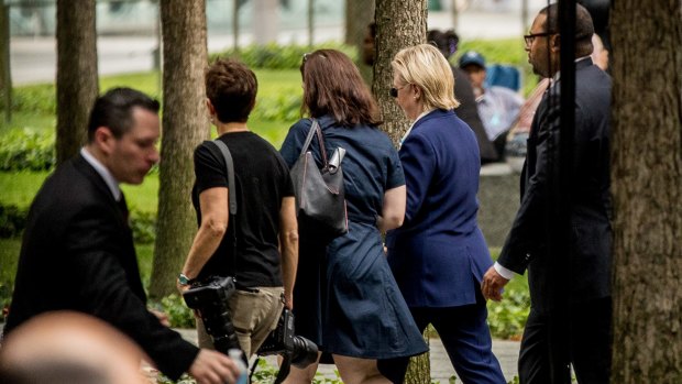 Hillary Clinton (right) is seen leaving the 9/11 ceremony early.