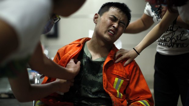An injured firefighter grimaces as he is examined in a hospital following the explosions. At least 21 firefighters are believed dead.