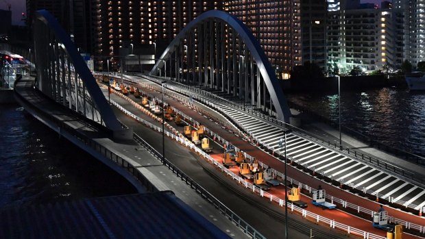 A group of turret trucks move over a bridge to new Toyosu market in Tokyo.