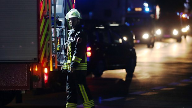 A firefighter stands at a road block in Wuerzburg after a man attacked people on a train.