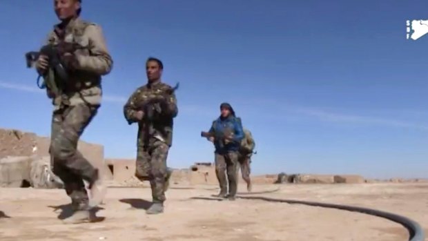 This frame grab from a video provided by the Syria Democratic Forces (SDF), shows fighters from the SDF running during fighting with Islamic State group militant, in Raqqa's eastern countryside, Syria, Monday, March 6.