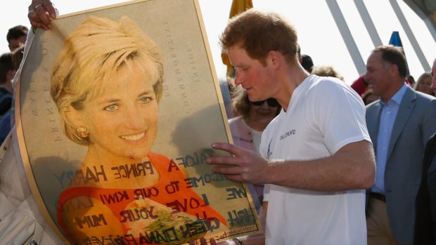 Prince Harry looks at a picture of his late mother Princess Diana from a fan in Auckland, 2015. 
