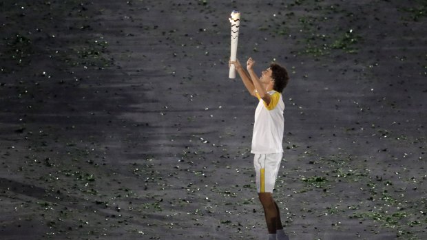 Gustavo Kuerten carries the Olympic torch.