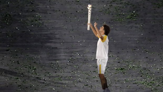 Gustavo Kuerten carries the Olympic torch.