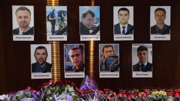Flower tributes in front of portraits of Russian TV journalists who were killed in the crash.