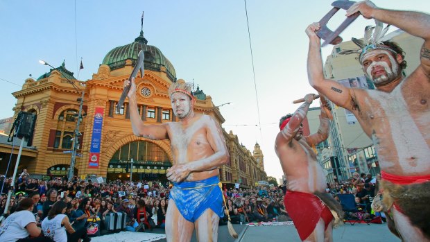 Aboriginal dancers perform  at the intersection of Flinders Street and Swanston Streets. 