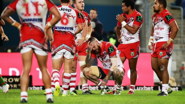Josh Dugan grimaces in pain after another Rabbitohs try.