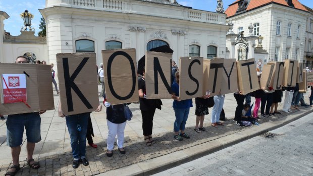 People hold boards with the word "Constitution" in front of the presidential palace Warsaw, Poland on July 24. 