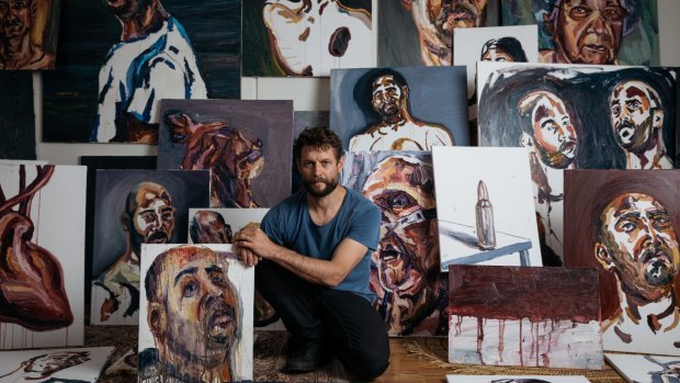 Artist Ben Quilty surrounded by works painted by Myuran Sukumaran while on death row.