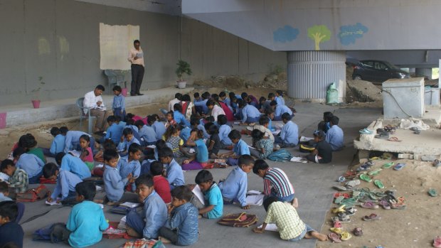 Rajesh Kumar Sharma and his pupils in their "classroom" under Yamuna Bank station.