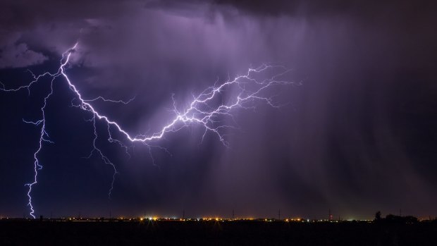 A woman has died and a man remains in hospital after being struck by lightning.