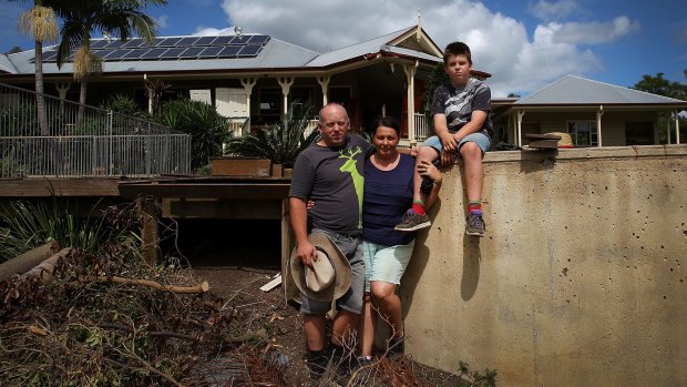 Daniel, Helen and Zander Gallo outside their home at Luscombe after 1.5 metres of floodwater went through it on April 3.