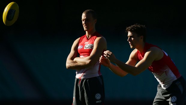 Mixed emotions: Ted Richards watches on as younger brother Xavier works through a handball drill at Swans training.