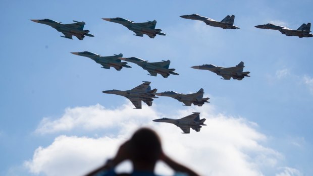 A man watches Russian military jets performing in Alabino, outside Moscow, Russia.