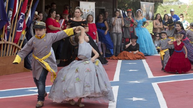 From the very old to the very young, descendants of American Southerners Wearing Confederate-era dresses and uniforms dance during a party to celebrate the 150th anniversary of the end of the American Civil War in Santa Barbara d'Oeste, Brazil.